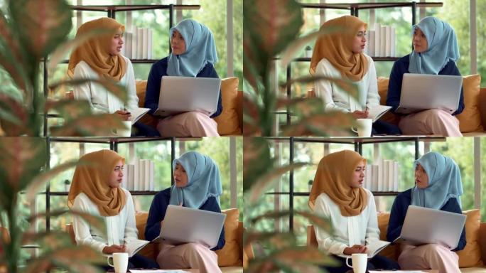 年轻的女商人用笔记本电脑向同事解释和打手势