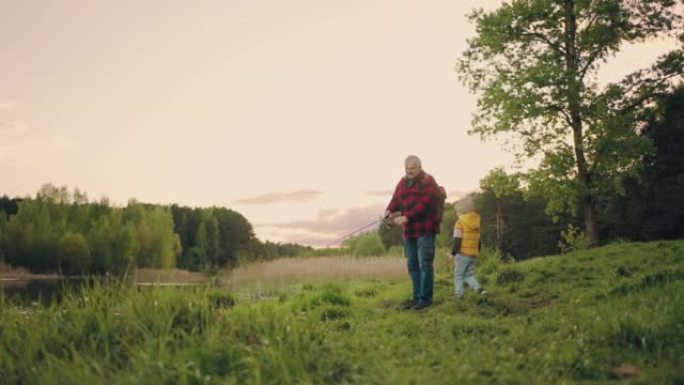 在美丽的森林湖畔钓鱼，祖父和他的孙子一起度过时光