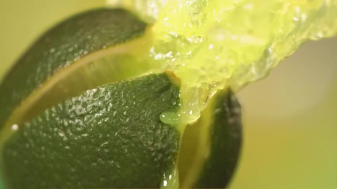 绿色自然背景下慢动作的新鲜酸橙水果喷汁4K