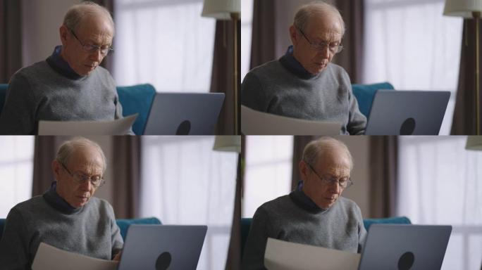 老人在家里工作，查看文件并使用笔记本电脑打字，是经验丰富的专家的远程工作