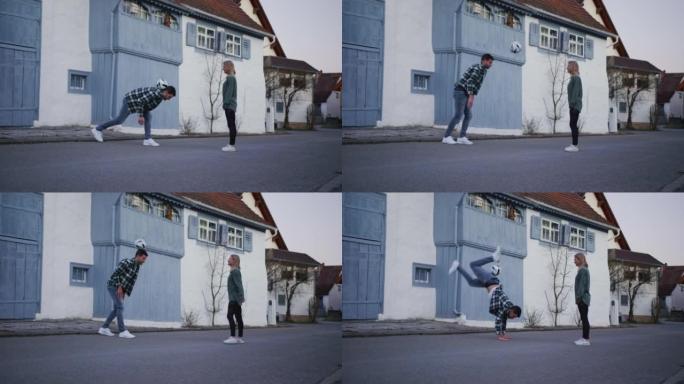 两人穿着便服在街上踢足球和耍花招