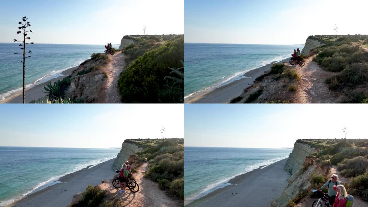 沿海岬角上骑自行车的夫妇的鸟瞰图