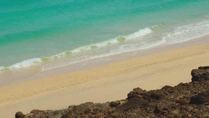空白色最佳细沙海滩。清澈见底的海水。海岸线上的岩石悬崖。新型冠状病毒肺炎后旅行放松概念。富埃特文图拉