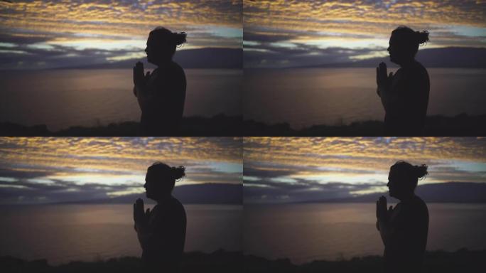 一个年轻人做瑜伽的剪影，背后是海洋日落