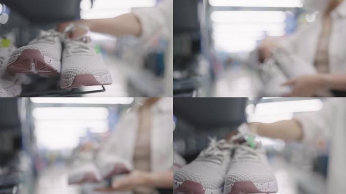 蒙面女人从架子上拿起运动鞋并将其退回的选择性焦点镜头
