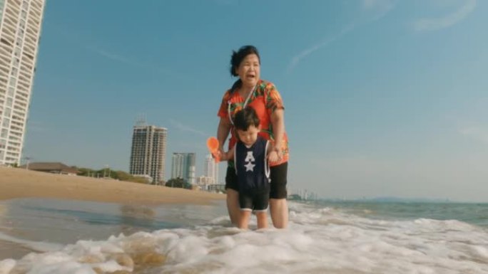 快乐的亚洲家庭在漫长的周末在海滩上享受时光。