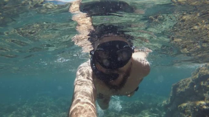 一个男人在夏天的海洋中游泳和浮潜的POV