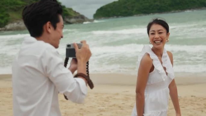 男子用相机捕捉与女友在海滩上的浪漫回忆