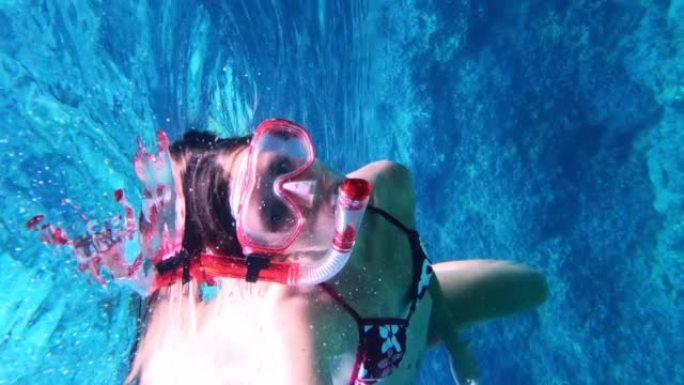 女人在海里浮潜。向可穿戴相机游泳。垂直视频