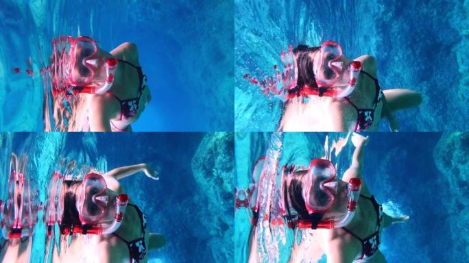 女人在海里浮潜。向可穿戴相机游泳。垂直视频
