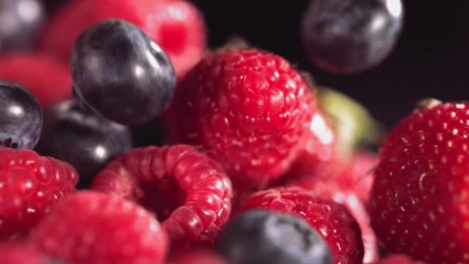 成熟多汁的草莓蓝莓覆盆子在许多混合浆果上滚动