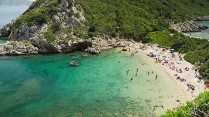 希腊科孚岛的蒂莫尼港海滩上的鸟瞰图人群。美丽的绿松石泻湖和海滩
