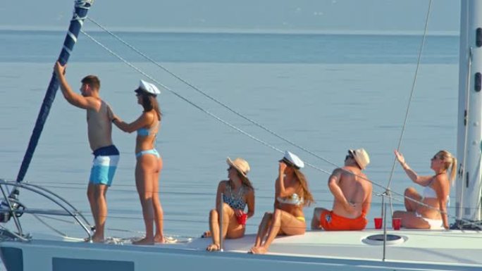 SLO MO女人在游艇上将乳液涂在男人的背上