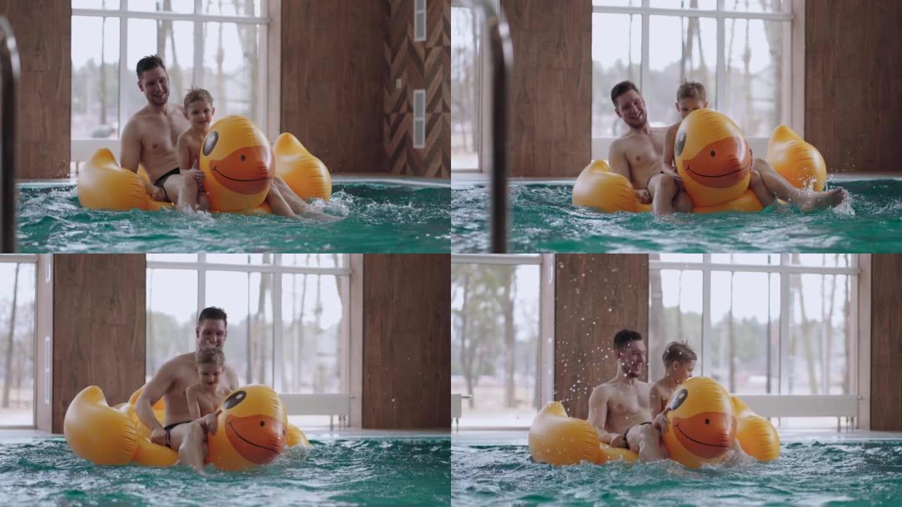 可爱的小男孩和他的爸爸在游泳池里骑着有趣的充气鸭，玩得开心，一起休息
