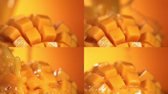 通过芒果立方体切片飞溅的芒果汁的慢动作镜头