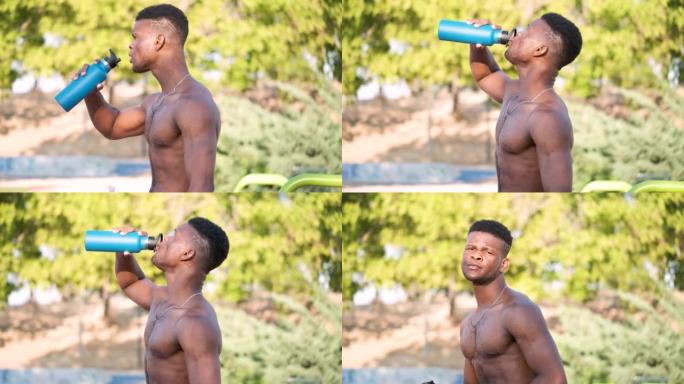 一个年轻健康的光着膀子的黑人在户外喝水的肖像。