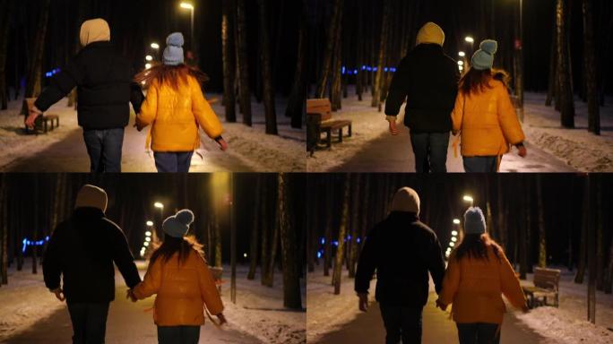 在寒冷的冬季街道上奔跑的快乐年轻夫妇的跟踪镜头。后视图快乐兴奋的有爱心的男人和女人在城市享受夜间休闲