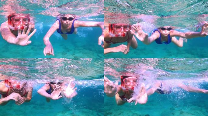 夏天在海里浮潜。女性朋友向可穿戴相机挥手。水下射击