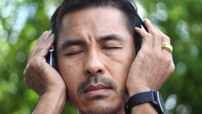 男人用无线耳机听音乐的特写镜头