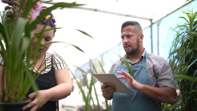推销员使用数字平板电脑并帮助客户购买鲜花