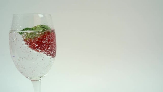装有苏打水和红色草莓水果的酒杯