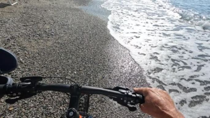 沿着海滩推自行车的第一人称视角