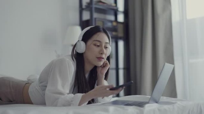 年轻女子在家中使用手机和笔记本电脑