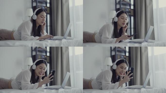 年轻女子在家中使用手机和笔记本电脑