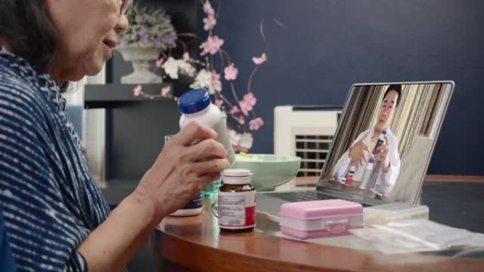 亚洲老年妇女通过视频通话与医生交谈。关于吸毒。