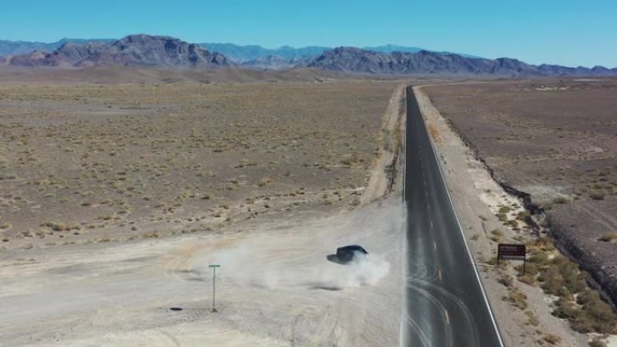 加州阳光照亮沙漠之路。汽车离开高速公路的鸟瞰图