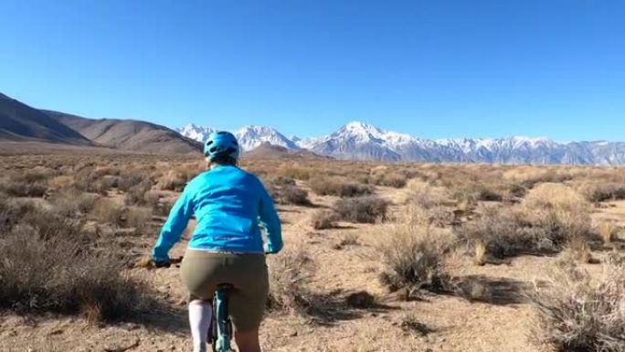 女性山地自行车手沿着沙漠小路