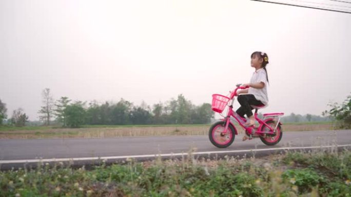 假期骑自行车锻炼的女孩。
