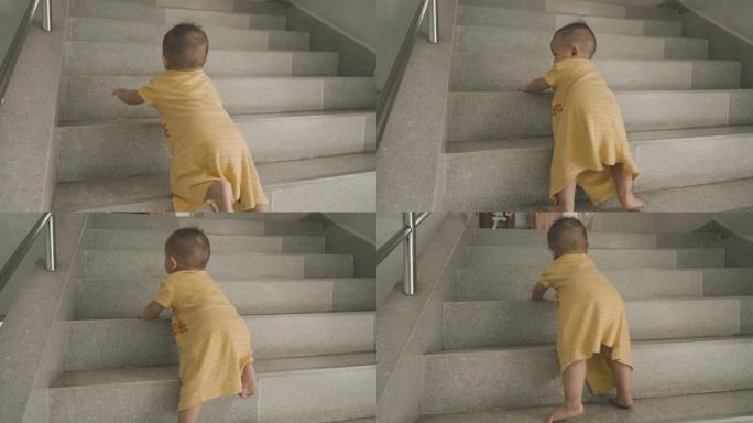 亚洲男婴在家里爬上台阶。