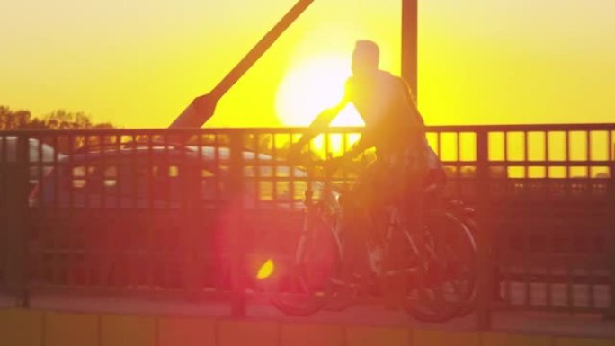 桥上骑自行车的人的鸟瞰图。日落期间的维斯杜拉河