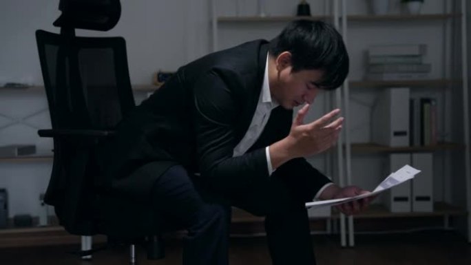 亚洲商人在办公室工作压力很大，似乎患有抑郁症。