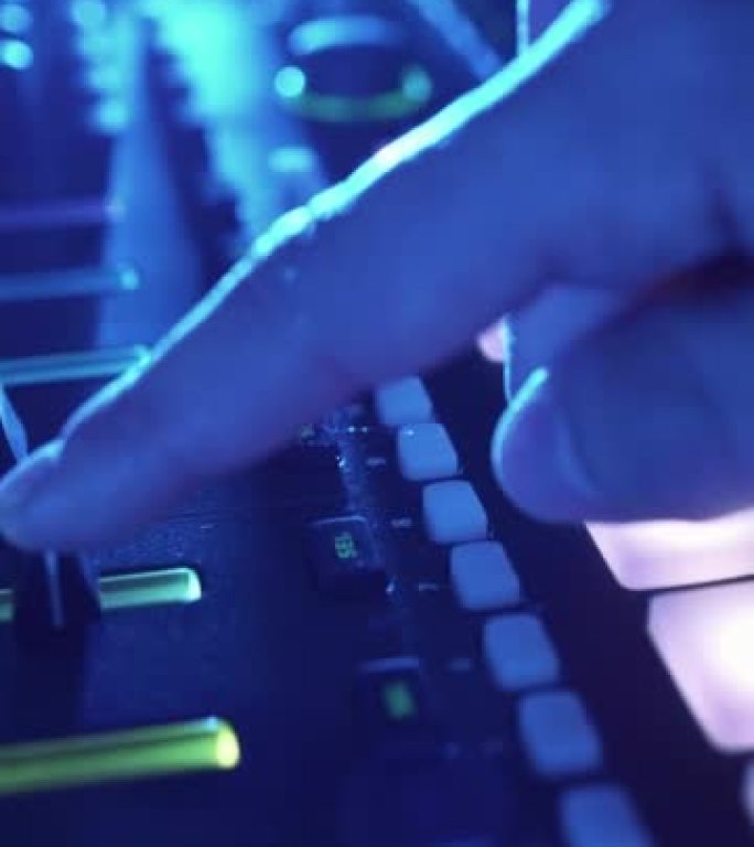 垂直视频专业DJ在工作室环境中播放节拍采样器彩色鼓垫和样本。Beatmaker在夜总会的派对上播放e