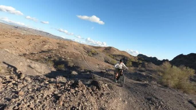 沿着沙漠小径骑自行车的第一人称视角