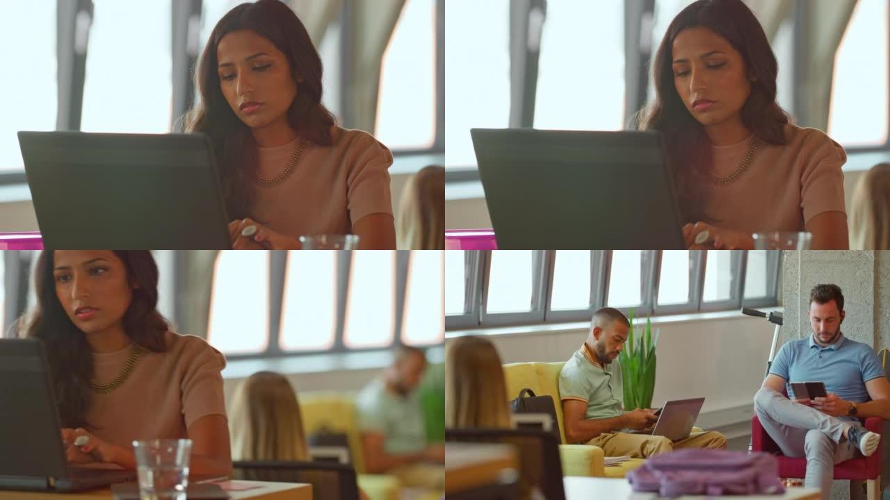 年轻女子在笔记本电脑上打字，两名男子在办公办公室的休息区工作
