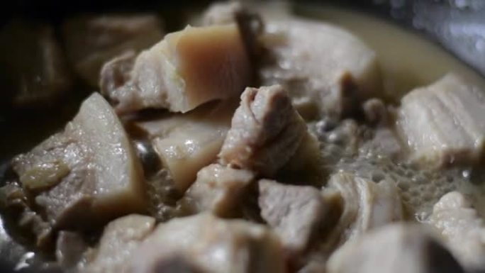 在锅里煮的猪肉肉是用冒泡的浓汤慢慢煮的。
