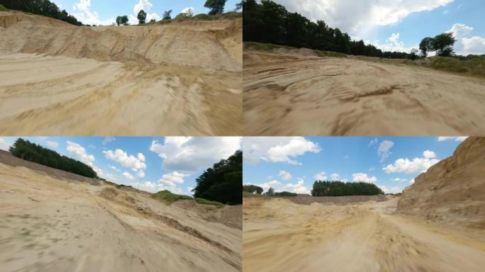 用赛车无人机拍摄沙雷。空旷平坦的地形覆盖着黄沙和重型机械步道