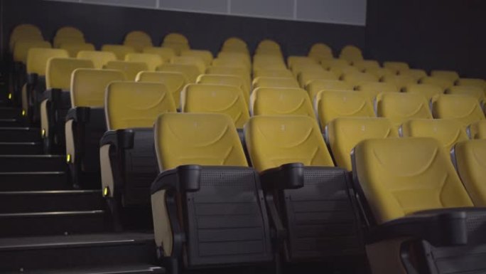 空荡荡的电影院大厅，一排排黄色椅子。电影院里没有人。娱乐设施的豪华内饰。
