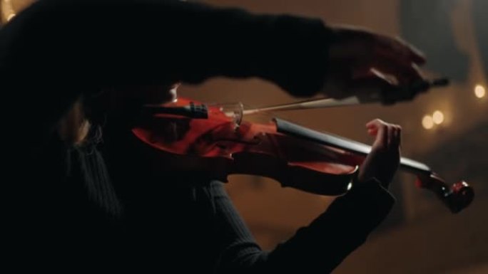 女小提琴手在交响乐团演奏，女人手中的小提琴特写镜头