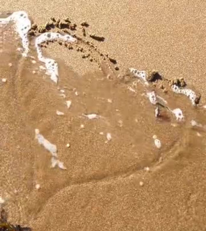 被大海卷走的沙子中画出的心形。心碎。