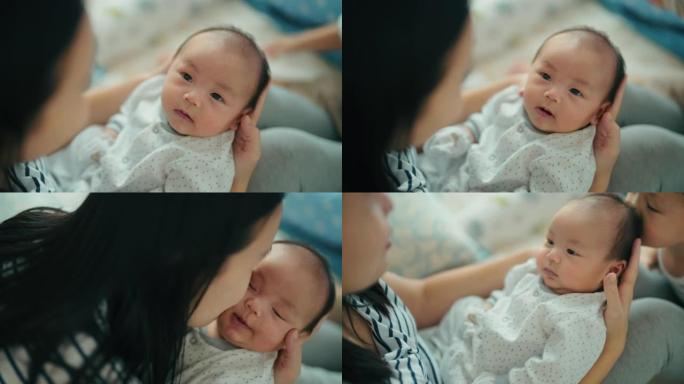 微笑的亚洲妈妈和她可爱的新生男婴玩耍