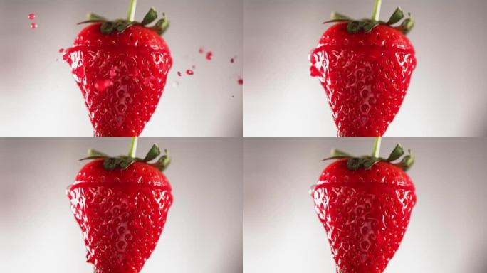 草莓切片掉落并溅到白色背景上。食物悬浮概念。慢动作