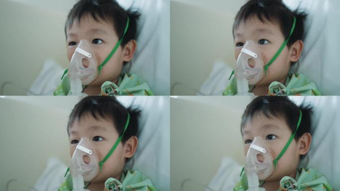 在医院接受氧气雾化器治疗的蹒跚学步的男孩。支气管炎和肺部疾病的吸入器治疗