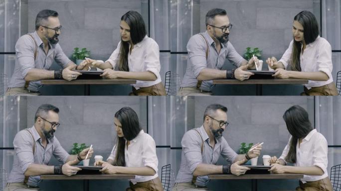 男子在咖啡厅向女友展示数字平板电脑上的东西