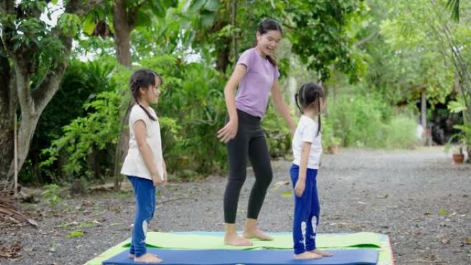 亚洲儿童瑜伽在绿色自然的房子里。