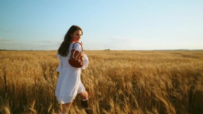 夏日无忧无虑的年轻女子正走在金色的麦田里，浪漫的乡村风格拍摄