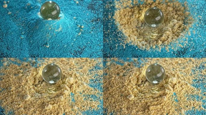 SLO MO LD玻璃球落入一堆蓝色和黄色的灰尘中